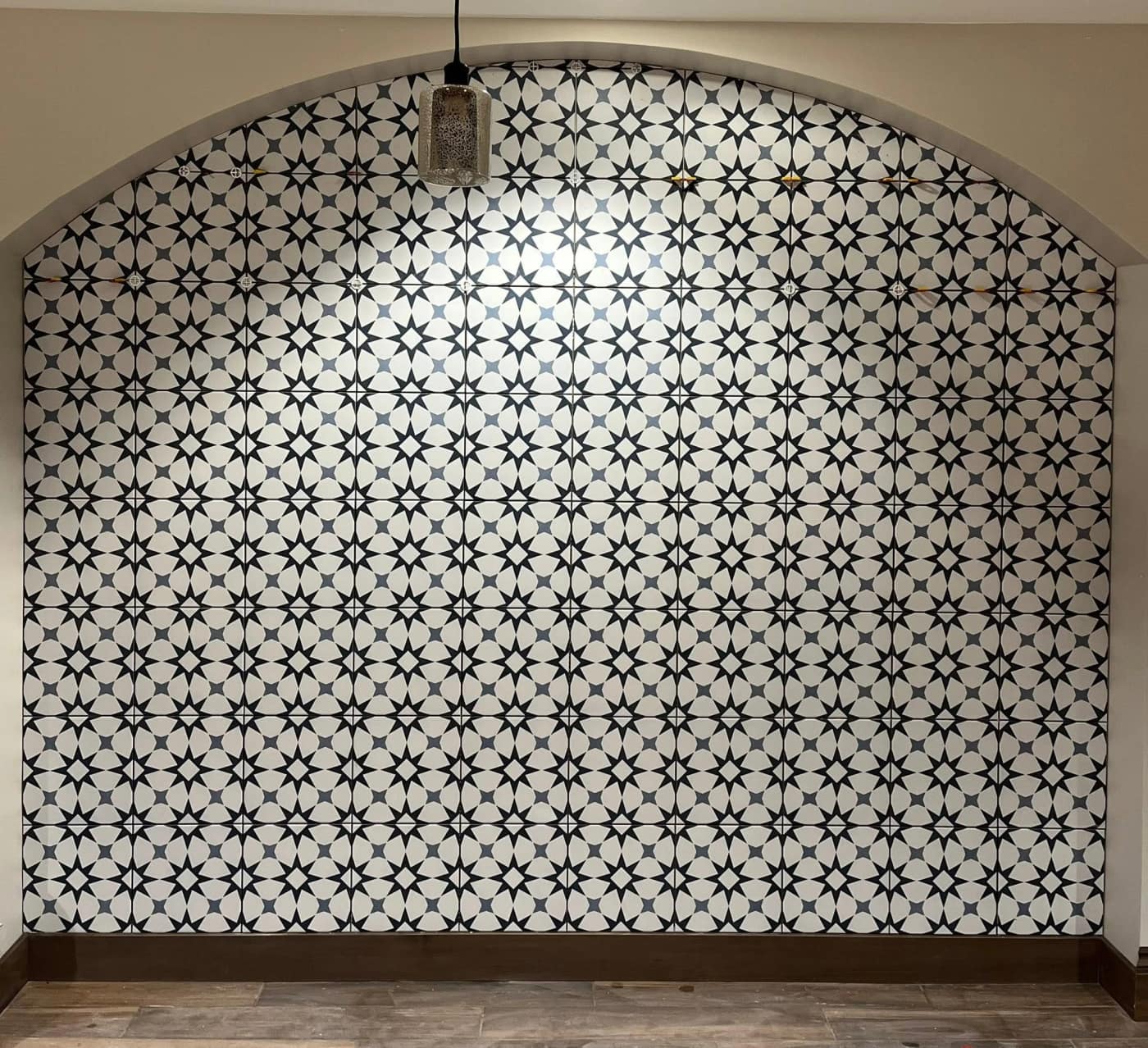 A patterned star-mosaic feature wall set beneath an arch at Chepo's